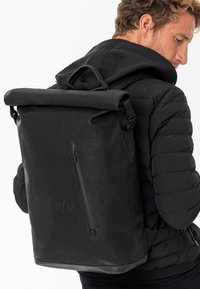 Zaino nero a roll-top realizzato in un tessuto impermeabile, con una texture liscia, tasca con zip e spallacci regolabili, caratterizzato da un sottile logo del marchio.