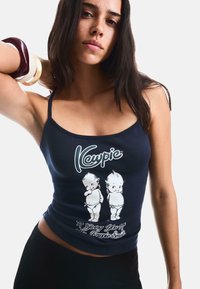 Navy tank top with a fitted design features a white graphic of two cartoon figures and the text "Kewpie." Smooth fabric without patterns.