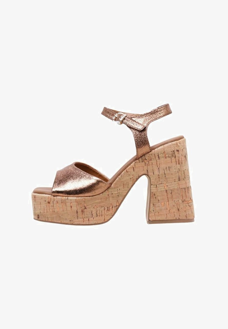 Sandalias de plataforma metálicas en bronce con tacón de corcho. Presentan una correa ajustable en el tobillo y un diseño de punta abierta. Superficie superior texturizada.