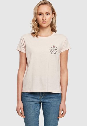 Light pink cotton t-shirt with short sleeves, featuring a simple black illustration of two birds with a heart, against a neutral background.