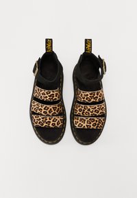 Sorte sandaler med leopardmønstrede stropper, med spænde lukning, tekstureret ruskind og gul syning langs sålen.