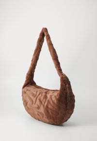 Borsa a mano in tessuto marrone con forma curva. La superficie testurizzata presenta un motivo ondulato. Spallaccio spesso e morbido per il trasporto. Finiture in oro.