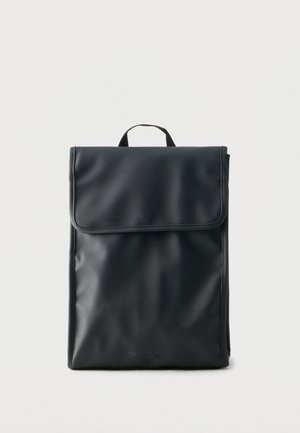 Melns taisnstūrveida mugursoma ar gludu tekstūru, augšējo atloku aizdari un mazu rokturi, uz vienkārša gaiša fona.