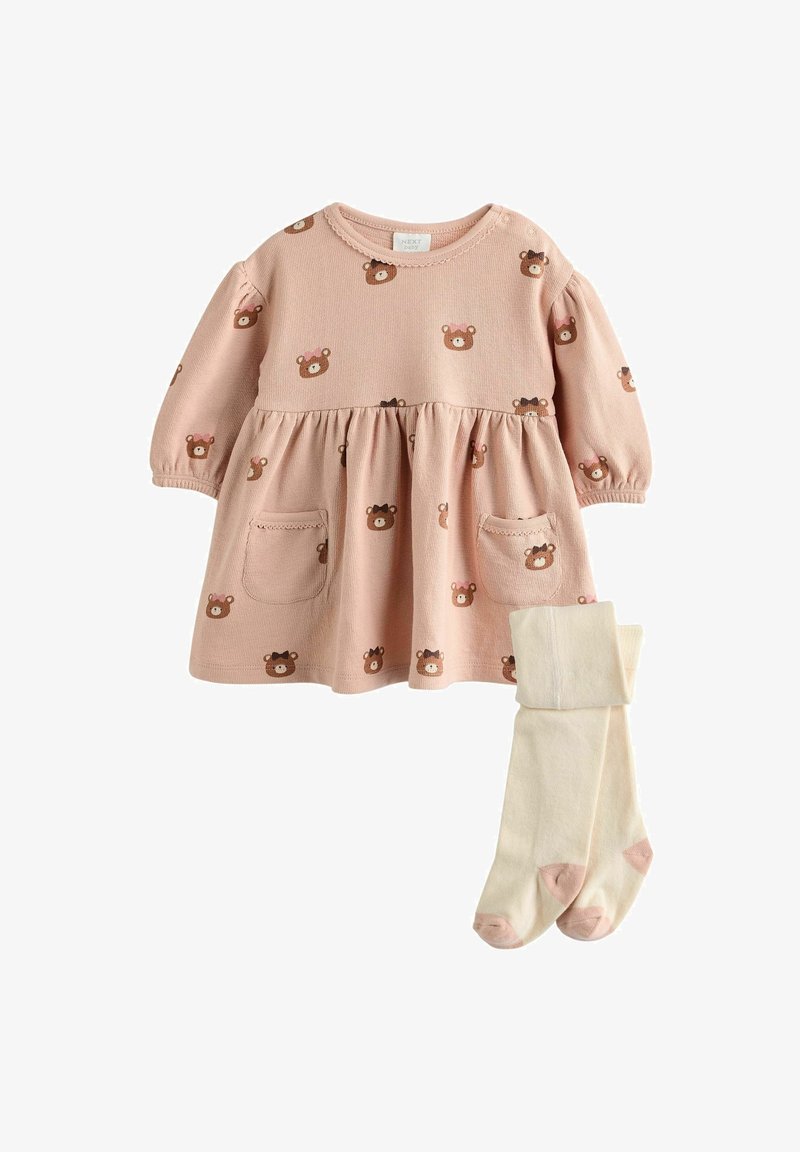 Robe bébé rose avec visages d'ours bruns imprimés, manches longues bouffantes, deux poches avant, associée à des collants crème avec orteils et talons roses.