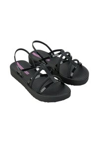 Czarne sandały z teksturowaną platformą i krzyżującymi się paskami. Paski są w połączeniu błyszczących i matowych wykończeń. Lekka konstrukcja.
