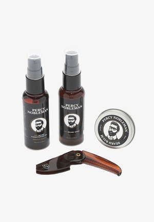 Drei Pflegeprodukte in dunklen Bernsteinflaschen mit schwarzen Etiketten, eine runde silberne Dose und ein brauner Kamm mit feinen Zähnen.