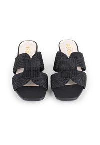 Des sandales à glissière tissées noires présentent un design à bretelles croisées, une semelle noire lisse et une semelle intérieure en beige rembourrée avec un marquage en texte doré.