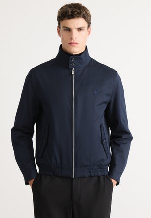 Navy blue bomber jacket featuring a high collar, front zipper, and side pockets with elastic cuffs at the hem for a fitted silhouette.