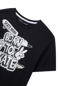 T-shirt nera in cotone con un design grafico che presenta il testo "SKATE MORE BORN TO SKATE" e un'illustrazione di una mano e di uno skateboard.
