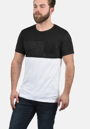 Black and white T-shirt with a speckled pattern on the upper section, round neck, and a chest pocket. Cotton material with a fitted design.