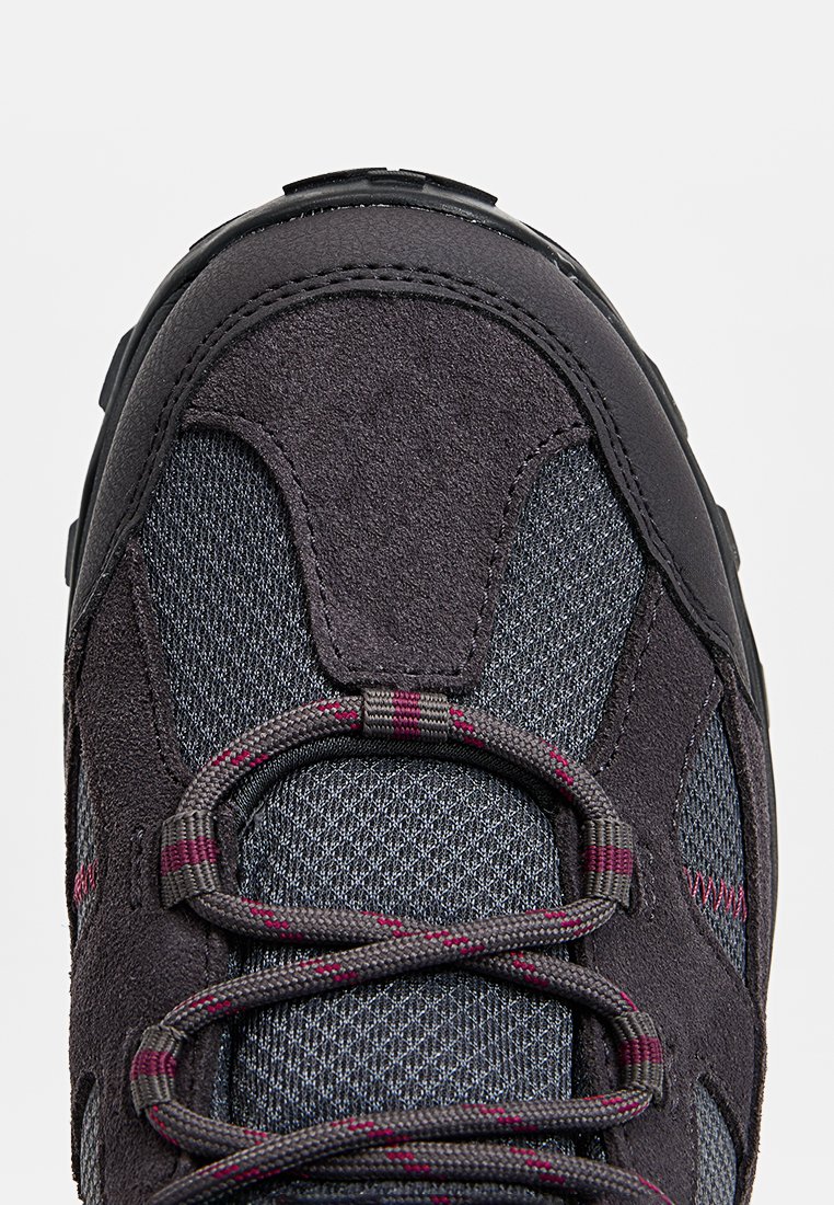 Buty trekkingowe z ciemnoszarym wierzchem wykonanym ze zamszu i siateczki. Charakteryzują się teksturowanym materiałem, różowo-czerwonymi akcentami oraz trwałą gumową podeszwą.