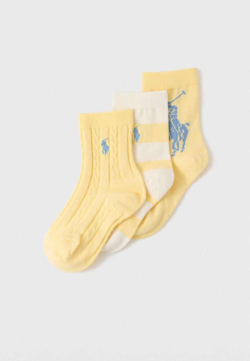 Három összehajtott baba zokni sárga és fehér színben, kék kupa lovas logóval, egyszínű, csíkos és kábelmintás kivitelben.