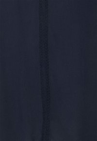 Dark navy fabric with a narrow vertical braided trim running down the center.