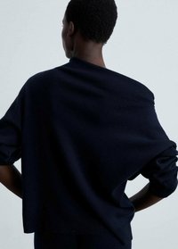 Maglione navy a maglia con maniche ampie e vestibilità rilassata. Il tessuto ha una finitura morbida e testurizzata con un ampio scollo.