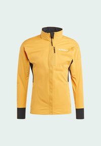 Yellow outdoor jacket featuring a full front zip, stand-up collar, black accents, and zippered pockets. Made from lightweight, stretch fabric.