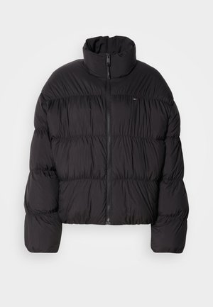 Μαύρο μπουφάν πούφ με ψηλό γιακά, κλείσιμο με φερμουάρ και οριζόντιες ραφές. Κατασκευασμένο από ελαφρύ, λείο ύφασμα.