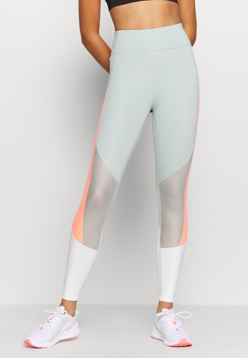 Leggings de color azul claro con acentos en coral y paneles de malla. El diseño de cintura alta presenta una textura suave y una forma ajustada, adecuada para ropa deportiva.