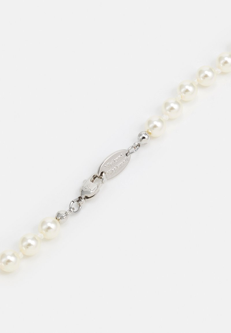 Hvid perlekæde med en sølvlås, som har glatte, runde perler og et kædedesign. Minimalistisk med en skinnende overflade.