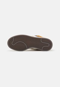 Suola in gomma per sneaker con un motivo a spina di pesce. Colore: marrone con accenti grigi chiari. Presenta una presa testurizzata e una forma sagomata.