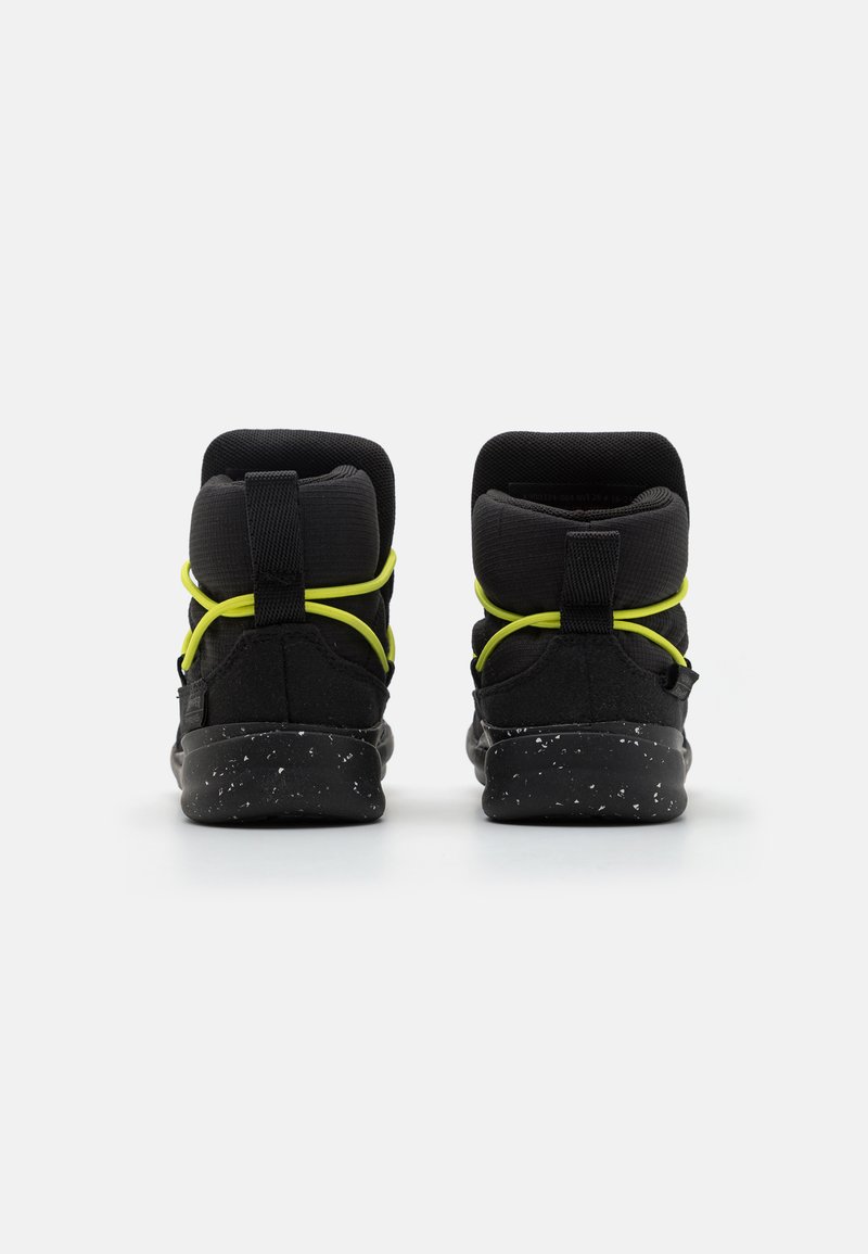 Sneaker alte nere con tomaia in tessuto testurizzato, lacci gialli e suola nera maculata. Progettate con supporto imbottito per la caviglia.