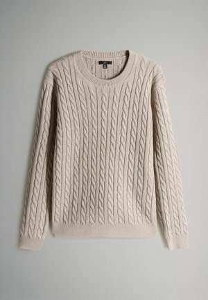 Svijetlosmeđi pleteni pulover s okruglim izrezom, dugim rukavima, rebrastim manžetama i donjim rubom. Mekana tekstura i istaknuti uzorak reljefa.