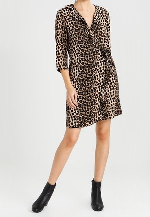 Robe à imprimé léopard avec un décolleté en V profond, des manches trois-quarts, un détail froncé à l'avant et une taille nouée, assortie à des bottines noires.