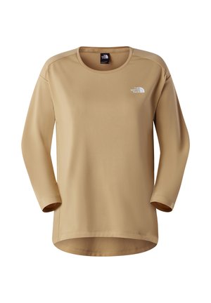 Camiseta beige de manga larga con cuello redondo, hecha de tela suave. Presenta el logotipo de The North Face en blanco en la parte superior izquierda del pecho.