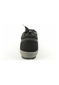 Scarpa in suede nera con una tomaia testurizzata, suola in gomma grigia e dettagli di cuciture bianche, vista da dietro.