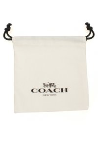 Bolsa de almacenamiento de lienzo blanco con un cordón negro, que presenta un logo impreso de "COACH NEW YORK" y un gráfico de caballo y carro.