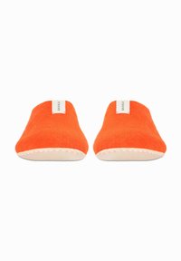 Oranje vilten slippers met een ronde neus, voorzien van een beige gestikte zool en een klein wit label op elke slipper.