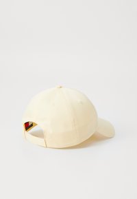 Žltá baseballová čiapka vyrobená z mäkkého materiálu, so zakriveným okrajom a nastaviteľným popruhom na zadnej strane s logom.