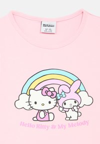 Pink bomulds t-shirt med Hello Kitty og My Melody grafik, en regnbue, korte ærmer og rund hals.