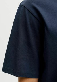 Marineblauw T-shirt met korte mouwen van katoen, met een zachte textuur en een ronde hals, met zichtbare stiksels langs de zoom.