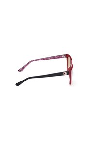 Gafas de sol de gran tamaño en rojo y negro con un interior de brazo de patrón geométrico, que presentan acentos dorados y una forma cuadrada.