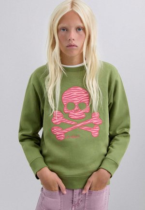 Sudadera verde hecha de mezcla de algodón con un gran gráfico frontal de una calavera y tibias cruzadas con rayas de cebra rosas. Mangas largas y puños acanalados.