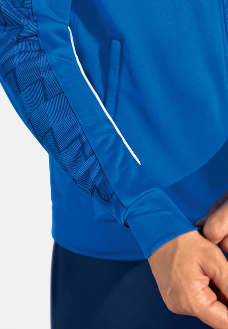 Blaue Sportjacke mit strukturiertem, gemustertem Ärmel, glattem Material und weißem Akzent entlang des Reißverschlusses.