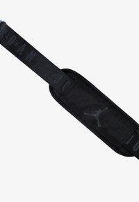 Correa de tela negra con una superficie texturizada, que presenta un prominente logo de Jumpman y una marca en relieve, diseñada para un ajuste seguro.