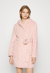 Pink, fluffy bathrobe with a hood, tied belt, and two front pockets; made of soft, textured fabric for comfort and warmth.
