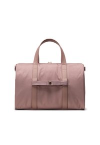 Sac de sport en tissu rose avec deux poignées courtes, une sangle centrale et des accents en métal doré. Texture lisse avec des lignes épurées et une forme rectangulaire.