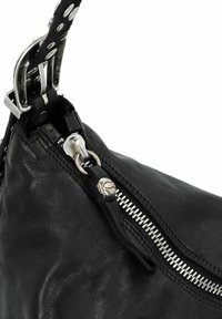 Zwarte leren handtas met een zilveren rits, metalen hardware en een gestructureerde afwerking. Verstelbare schouderriem met studdetails voegt contrast toe.