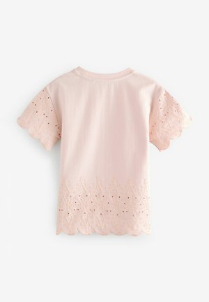 Roza majica z kratkimi rokavi, ki ima obrobe iz čipke z valovitimi robovi na spodnjem delu in rokavih, okrašena z vezenjem in majhnimi izrezki v obliki okroglih lukenj.
