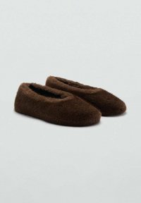 Zapatillas de casa de pelo marrón con una textura suave, punta redondeada y un diseño bajo. Presentan una superficie lisa sin hardware visible ni patrones.