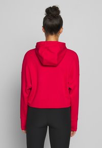 Sudadera corta roja con capucha ajustable y mangas largas, hecha de una tela suave y lisa, con un corte relajado.