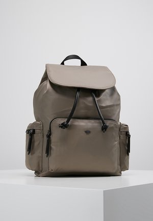 Grå nylon rygsæk med klaplukning, justerbare stropper, snøre top og flere lynlåslommer. Glat tekstur og minimale detaljer.