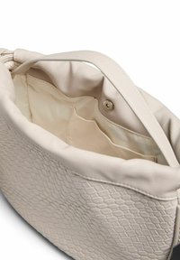 Kermainen nahkalaukku, jossa on teksturoitu, skaalattuja muotoja. Sisäosa on vuorattu vaaleanbeigeillä kankailla ja siinä on tasku, jossa on napin suljenta.