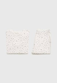 Valkoinen pyjama-setti, joka koostuu lyhythihaisesta paidasta ja samansuuruisista housuista, koristeltuna tummansinisillä tähtikuvioilla. Pehmeä kangas ja rento istuvuus.