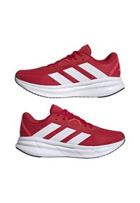 Red athletic shoes with a mesh upper, white stripes, and a black rubber outsole. Features a padded collar and CLOUDFOAM cushioning.