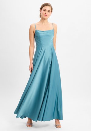 Un lungo abito da sera color teal con spalline sottili, un corpino drappeggiato e una gonna fluida; realizzato in un tessuto liscio simile alla satin.