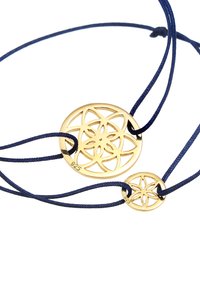 Colgantes en tono dorado con patrón sobre un cordón azul marino. Presenta un colgante circular más grande y otro más pequeño, ambos con diseños florales.