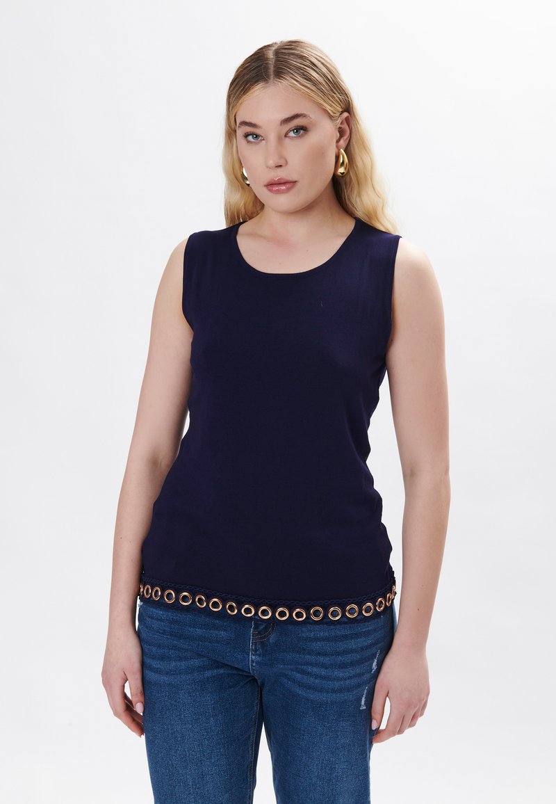 Top senza maniche blu navy con scollatura rotonda e occhielli circolari sul bordo. Realizzato in tessuto morbido, abbinato a jeans in denim blu.